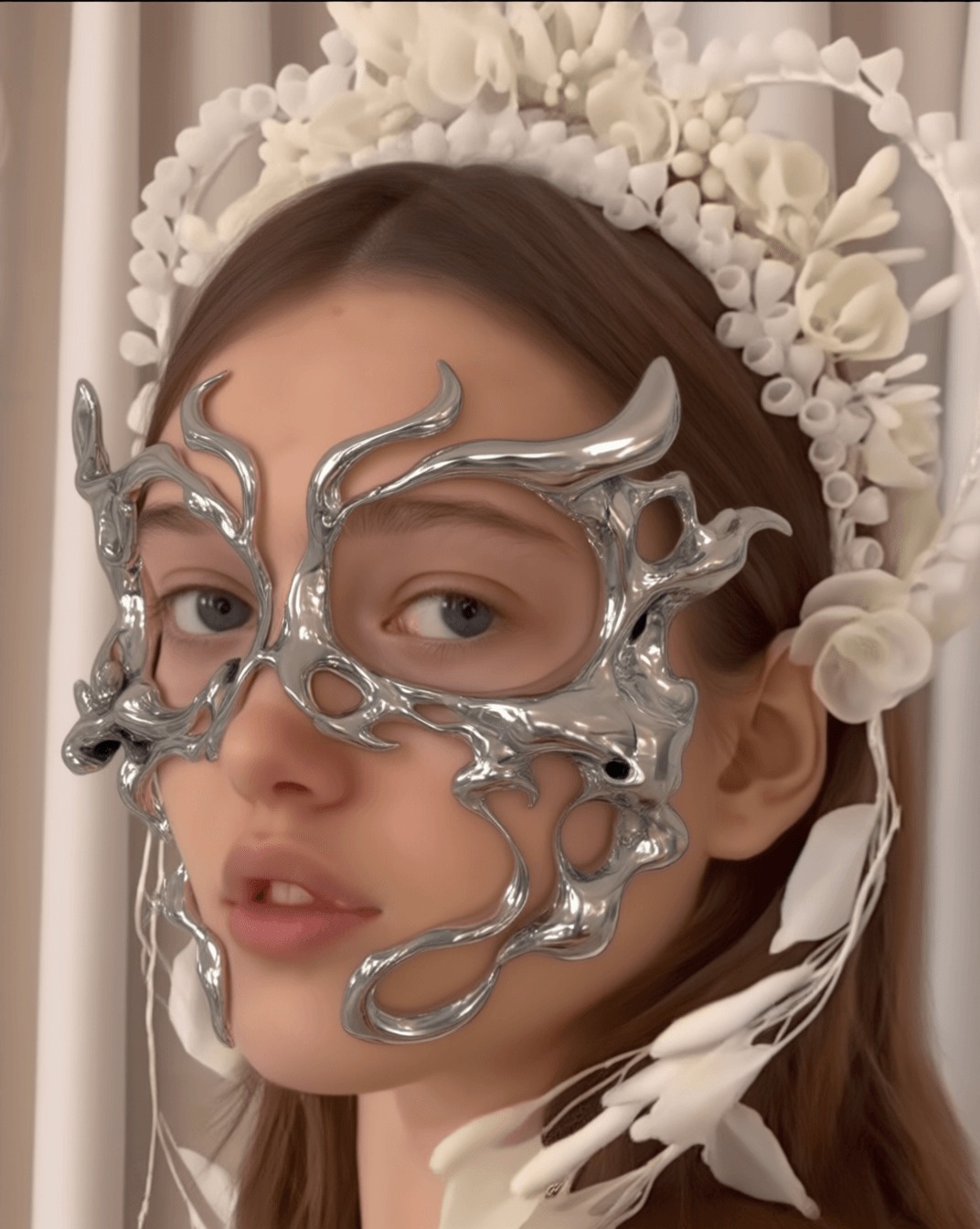Portrait wearing a liquid-chrome mask and white ceramic floral crown, generated on TITLES