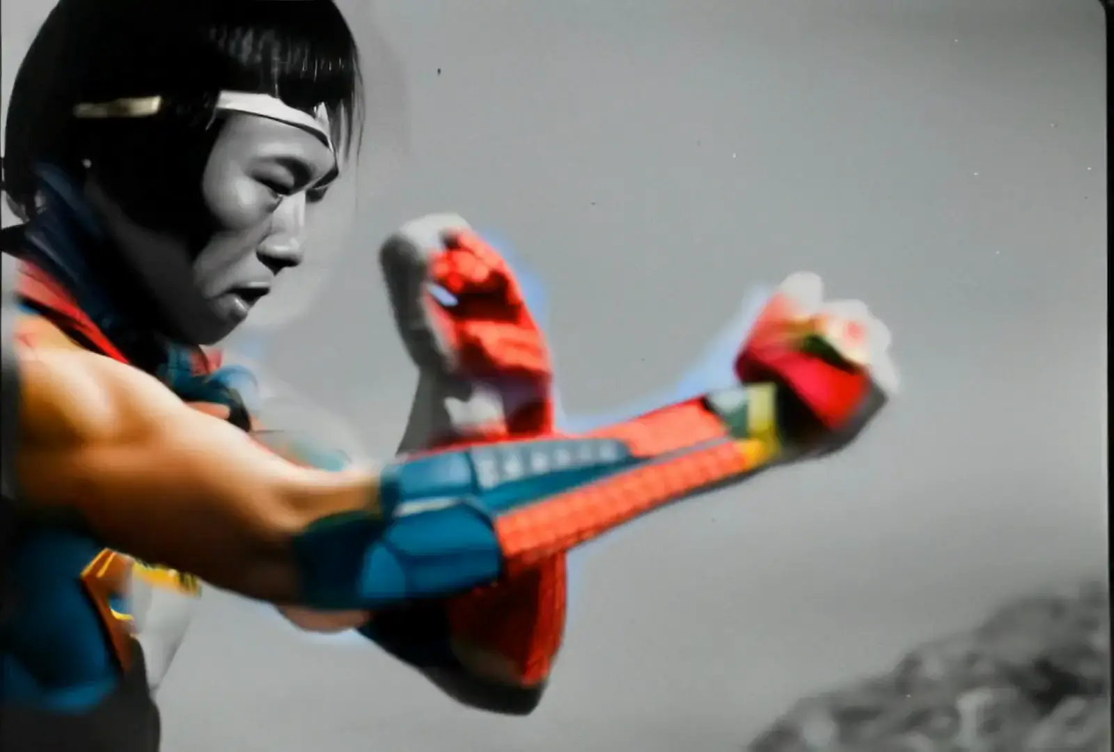 Figure with colorful superhero arm gloves against grey sky, blending martial arts and comics